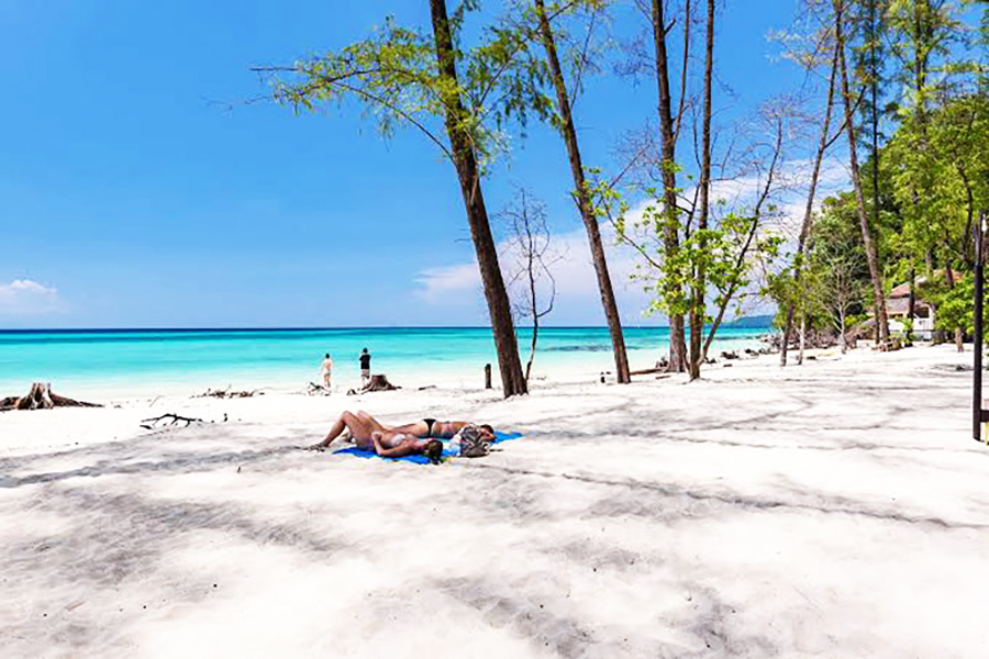 Prendere il sole sulla spiaggia di sabbia bianca